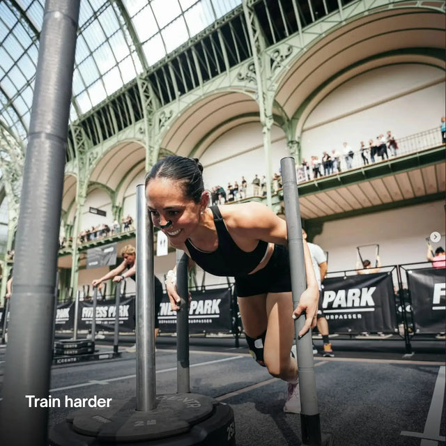 Woman participating in an obstacle course event in a large indoor arena with AirMag Pro Nasal Strips